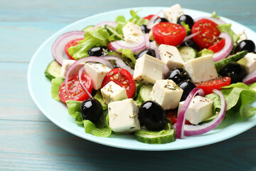 Delicious salad with feta cheese on blue wooden table, closeup