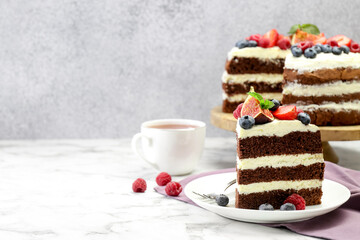 Piece of delicious chocolate sponge cake with berries served on white table. Space for text