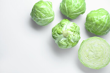 Fototapeta premium Raw green cabbages on white background, flat lay. Space for text