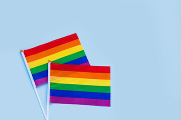 LGBT rainbow flag flat lay on light blue color background. gay marriage, human rights, june parade, lgbtq proud history month concept, coming out day. top view, place for text or logo