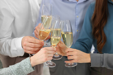 Happy coworkers clinking glasses of wine during office Christmas party, closeup