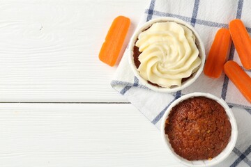 Tasty carrot muffins with fresh vegetables on white wooden table, flat lay. Space for text