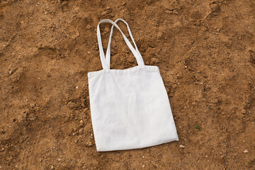 White cotton or mesh bag on beach sand background. Zero waste, no plastic, eco friendly shopping,...