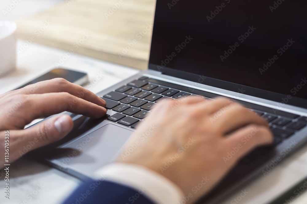 Poster with the office setting blurred in the backdrop, the image shows a close-up of a man's hands typing 