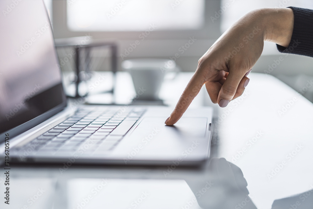 Poster a detailed view of female hands typing on a cutting-edge laptop keyboard, set against a hazy office 