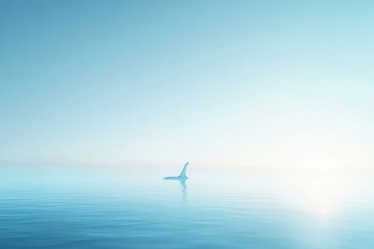 Against a backdrop of blue clouds, a shark's fin slices through the ocean's surface