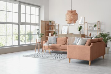 Interior of light living room with sofas, shelf units and plants