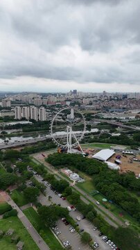 V&iacute;deo vertical da roda gigante no Parque Villa Lobos, em S&atilde;o Paulo, destacando a atra&ccedil;&atilde;o e a paisagem urbana ao redor, oferecendo uma vista panor&acirc;mica da cidade