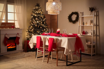 Interior of dark room with dining table, fireplace and Christmas tree