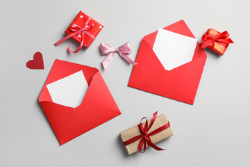 Envelopes with blank cards and gift boxes on grey background. Valentine's day celebration