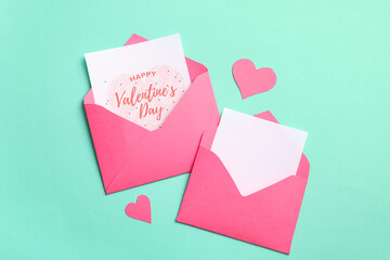 Envelopes with gift cards and paper hearts on turquoise background. Valentine's day celebration