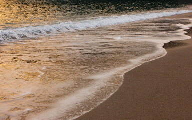 The wave breaks on the shore. White sea foam silhouette