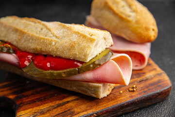 Sandwich ham, baguette, pickle cucumber, tomato sauce, mustard fast food fresh tasty food dish...