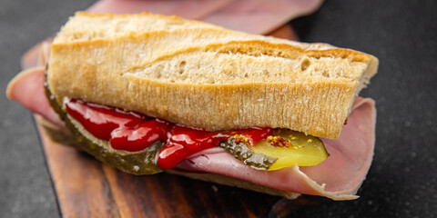 Sandwich ham, baguette, pickle cucumber, tomato sauce, mustard fast food fresh tasty food dish delicious gourmet food background on the table rustic food top view copy space