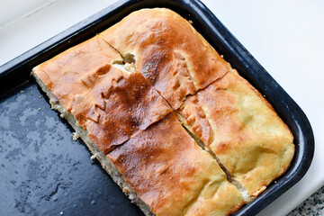 A beautiful and juicy meat pie on a baking sheet. Delicious potato pie.