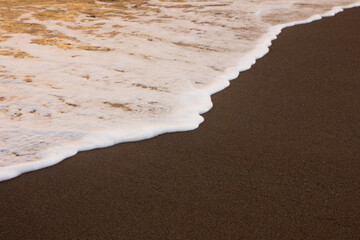 The wave breaks on the shore. White sea foam silhouette