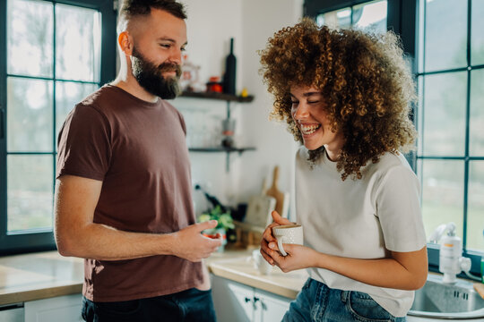 Happy couple enjoying a cheerful morning conversation in kitchen