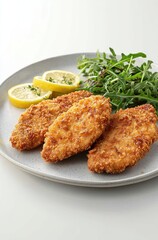A delicious presentation of crispy fried chicken fillets served with fresh greens and lemon, perfect for a satisfying meal.