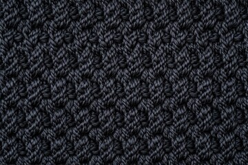 Close-up of a dark black knitted texture, showcasing intricate patterns and a cozy feel.