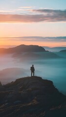 Serene Sunrise Over Misty Mountains with Lone Hiker Silhouette