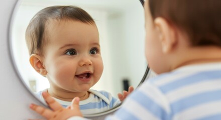 Fototapeta premium Joyful caucasian baby smiling at reflection in mirror
