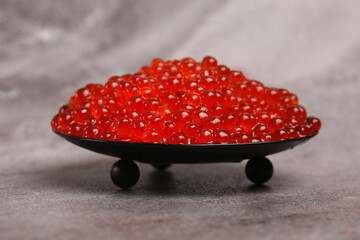 plate with red caviar on a light background