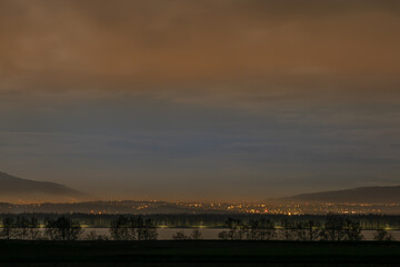 nocna panorama miasta z górawmi w tle	