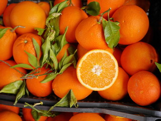 A pile of oranges with one cut open