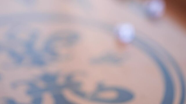 Hand is rolling the dice on the backgammon board, closeup view. Player throwing a dice during the backgammon game.