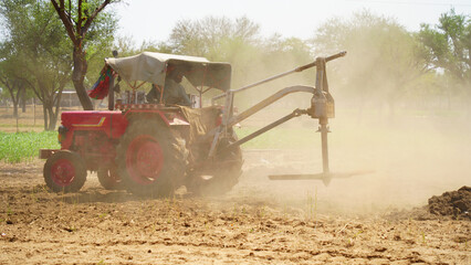 Tractor spreading organic fertilizer on farmland with dust flow in action. Farmers preparing the...