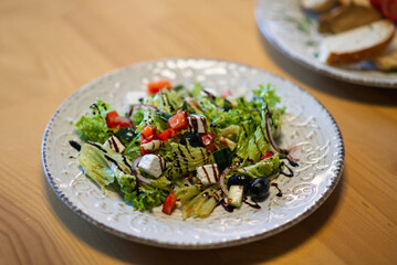Fresh Greek Salad with Feta and Balsamic Dressing on Elegant Tableware for Healthy Eating Concept