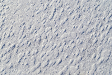 Close-up of fresh and bright snowy land in the winter on a sunny day, viewed from above. Abstract full frame textured background with copy space. Top view.