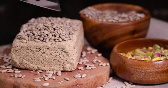halva from roasted sunflower seeds close up, a sweet delicious dessert made from fried sunflower seeds, wooden bowl