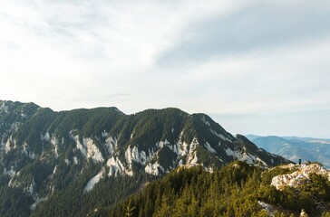 Towering peaks rise majestically against a soft morning sky, inviting exploration and wonder. Lush greenery blankets the hillsides, creating a perfect backdrop for outdoor enthusiasts