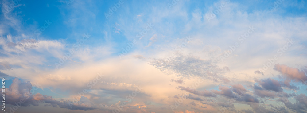 Poster the sky is blue panorama with a few clouds. the clouds are white and scattered. the sky is clear and