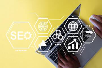 SEO(Search Engine Optimization),Keywords, Digital Marketing Strategies, Website Ranking, Analytics Tools Concept.,SEO interface and icon on top view laptop over yellow background with copyspace.