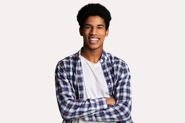 Happy teen guy posing with crossed hands and smiling to camera over white background