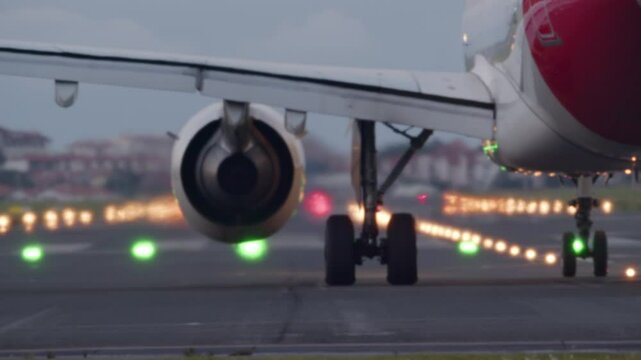 Passenger airplane accelerates down the runway, lifting off into the sky from an airport during twilight hours