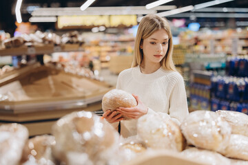 Customer choosing bread in supermarket bakery section