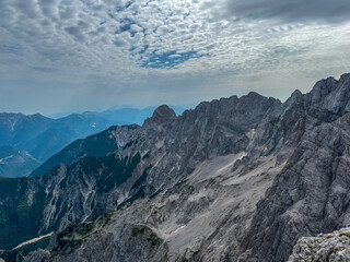 Panoramic view of rugged mountain ridges of majestic Julian Alps seen from top of summit Spik....