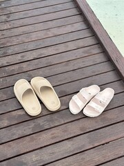slippers on a wooden path made from dark wooden planks on a resort in the Maldives
