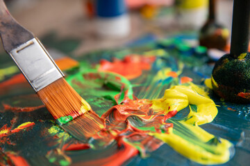 Obraz premium The vibrant paint blends beautifully on the artists palette alongside a brush, creating art