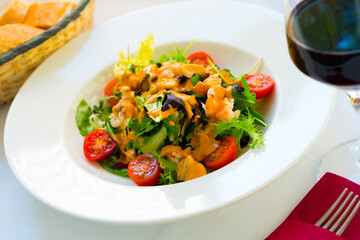 Plate of delicious salad with seafood, greens and pink sauce