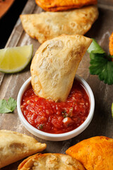 Freshly served traditional empanadas on wooden board. Mexican food