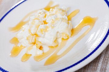 Portion of cottage cheese with sweet honey closeup