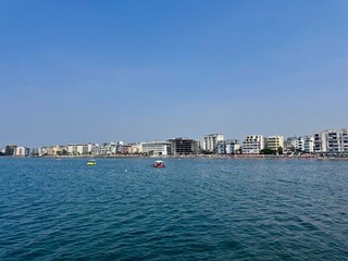 Fototapeta premium view of a coastline of Durres in Albania with waterfront buildings and a sandy beach of the Adriatic sea on a sunny summer day 