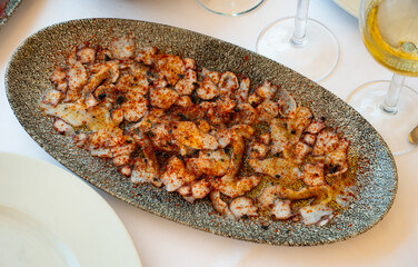 Delicious octopus carpaccio seasoned with aromatic oil and smoked paprika served on plate. Seafood appetizer