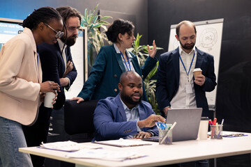 Sales analysts reviewing market trends and statistics in a conference room, meeting to create a new...