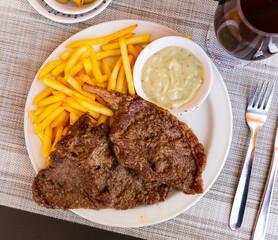 Traditional french cuisine, baked pork steak with roquefort cheese in a restaurant