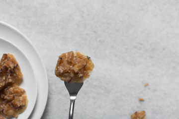 Overhead view of nigerian coconut candy on a white plate, top view of candied coconuts discs, flatlay of bukayo candy or coconut drops